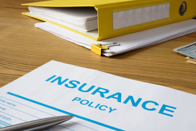 Insurance policy with pen and folder.