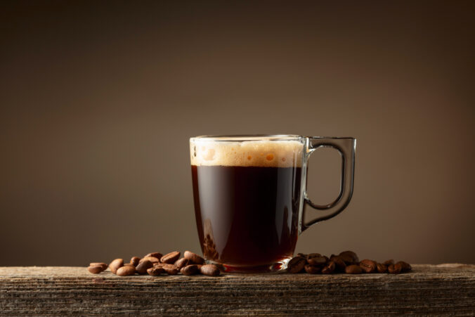 Espresso coffee glass cup on a brown background.