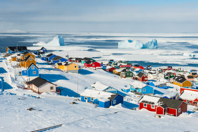 Village overlooking sea with icebergs