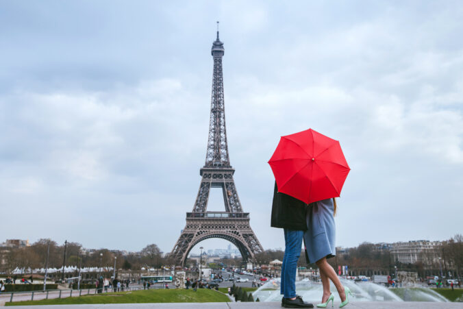 Couple kissing behind umbrella in Paris