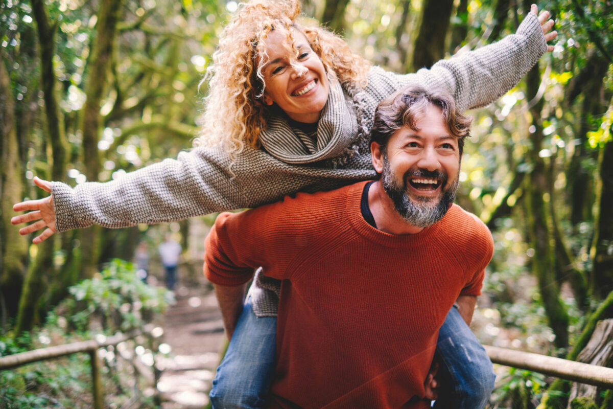 Overjoyed adult couple have fun together at outdoor park in leis