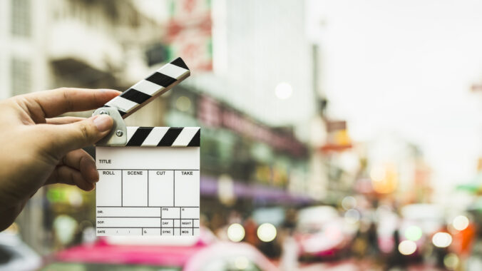 Assistant director holding a film slate on Yaowarat Road, which is Thailand&#039;s Chinatown and is popular for filming concept films about the film industry and shooting content on social media.