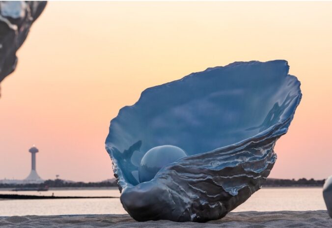 Detailná fotografia dúhovej ustrice so zabudovaným reproduktorom, ktorý je súčasťou umeleckej inštalácie Homesickness na pobreží Corniche v Abú Zabí.