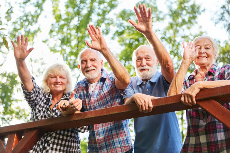 Happy seniors wave from a bridge