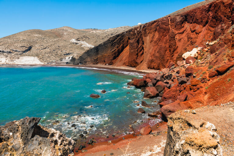 Červená pláž na ostrove Santorini, Grécko. Červené sopečné útesy a modré more za slnečného dňa.