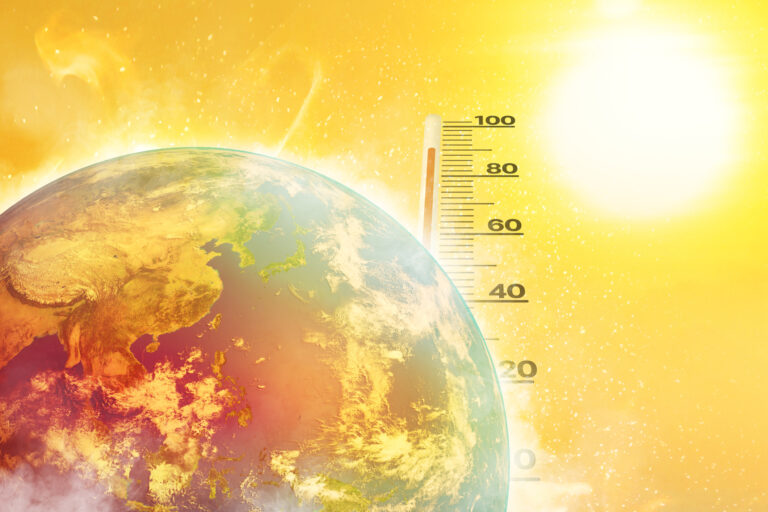 Zem s rastúcou teplotou a teplomerom na pozadí symbolizujúca globálne otepľovanie a klimatickú krízu