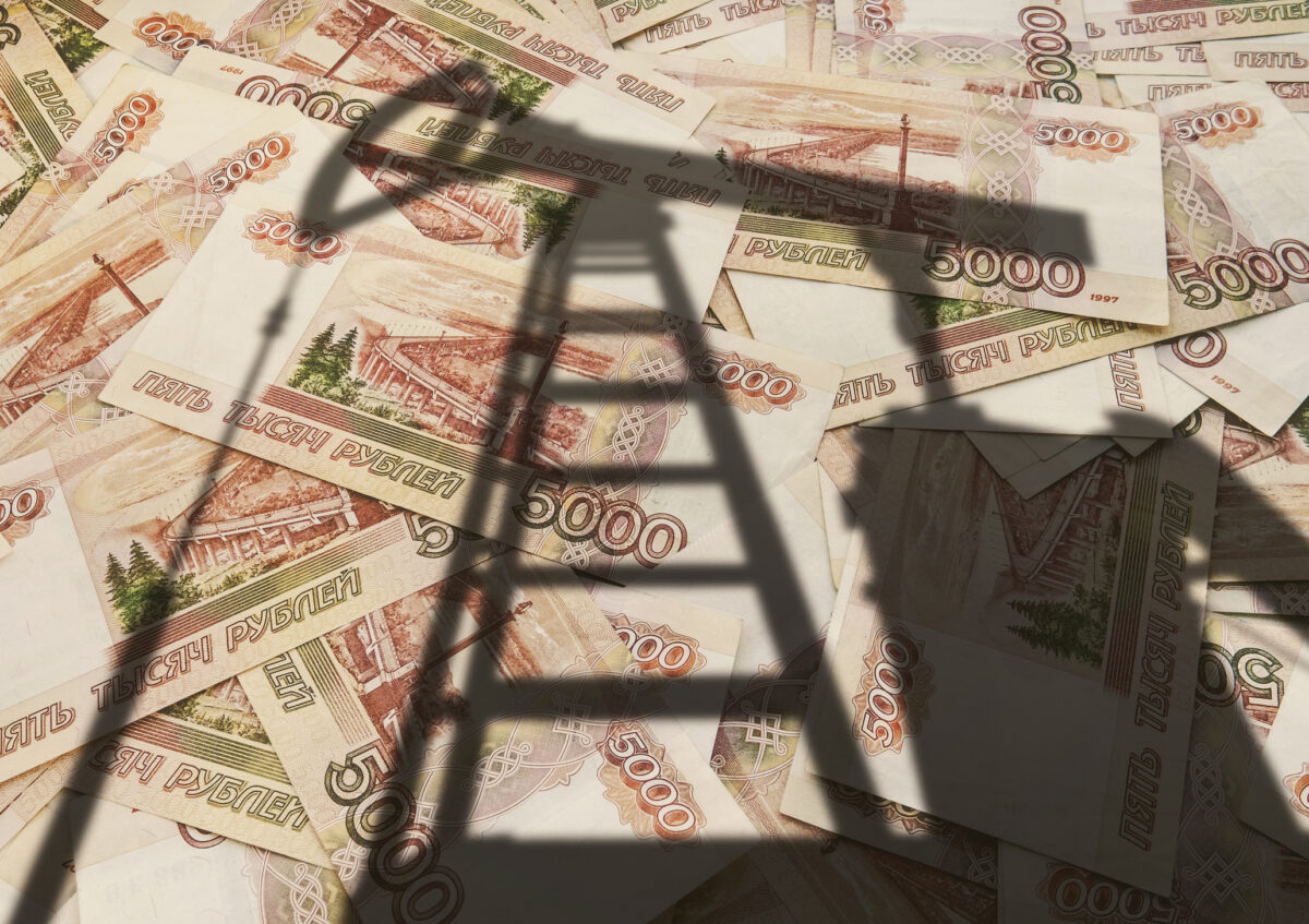 Concept of selling minerals for Russian rubles. The shadow of the oil rig against the background of Russian money. Earn money from mining gas and oil energy resources