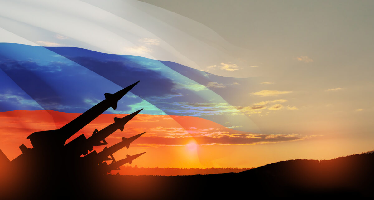 The missiles are aimed at the sky at sunset with Russian flag. Nuclear bomb, chemical weapons, missile defense.