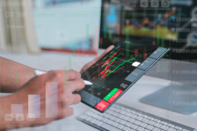 Investment and finance concept, businessman using pen and computer tablet woking or analysing on virtual trading graph background, stock market, profits and business growth