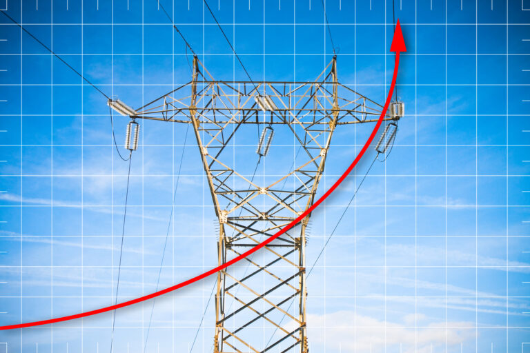 Hand drawing a graph about energy production - concept image with power tower and transmission lines on blue background