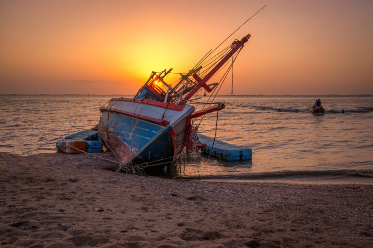 An old shipwreck or abandoned shipwreck.,Wrecked boat abandoned stand on beach or Shipwrecked off the coast of Thailand.