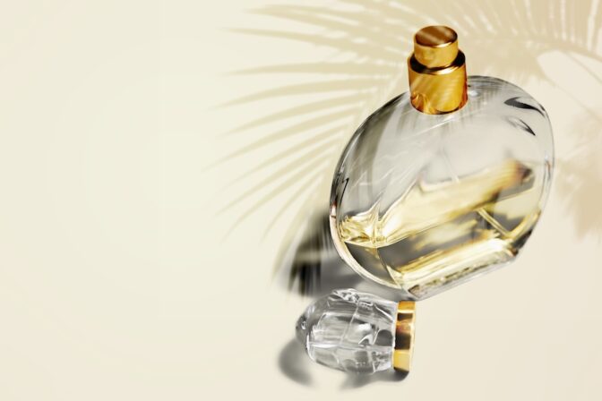 Bottle of perfume with palm leaf shadows.