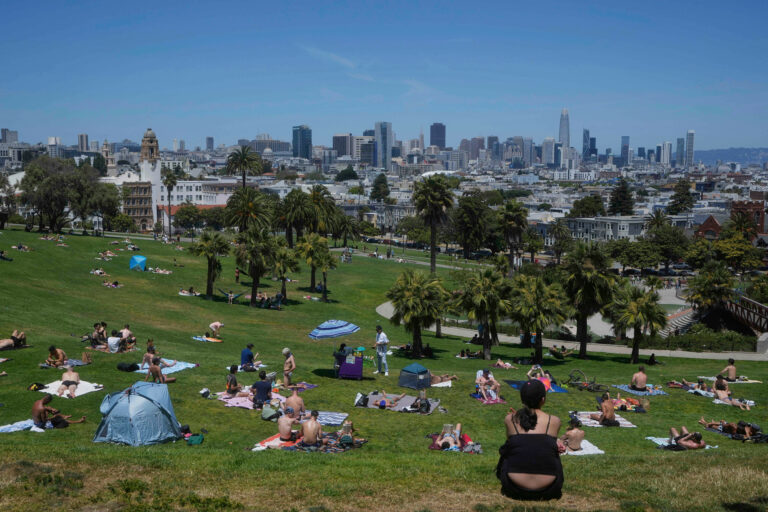 teplo ľudia opaľovanie tráva lúka mesto mrakodrapy