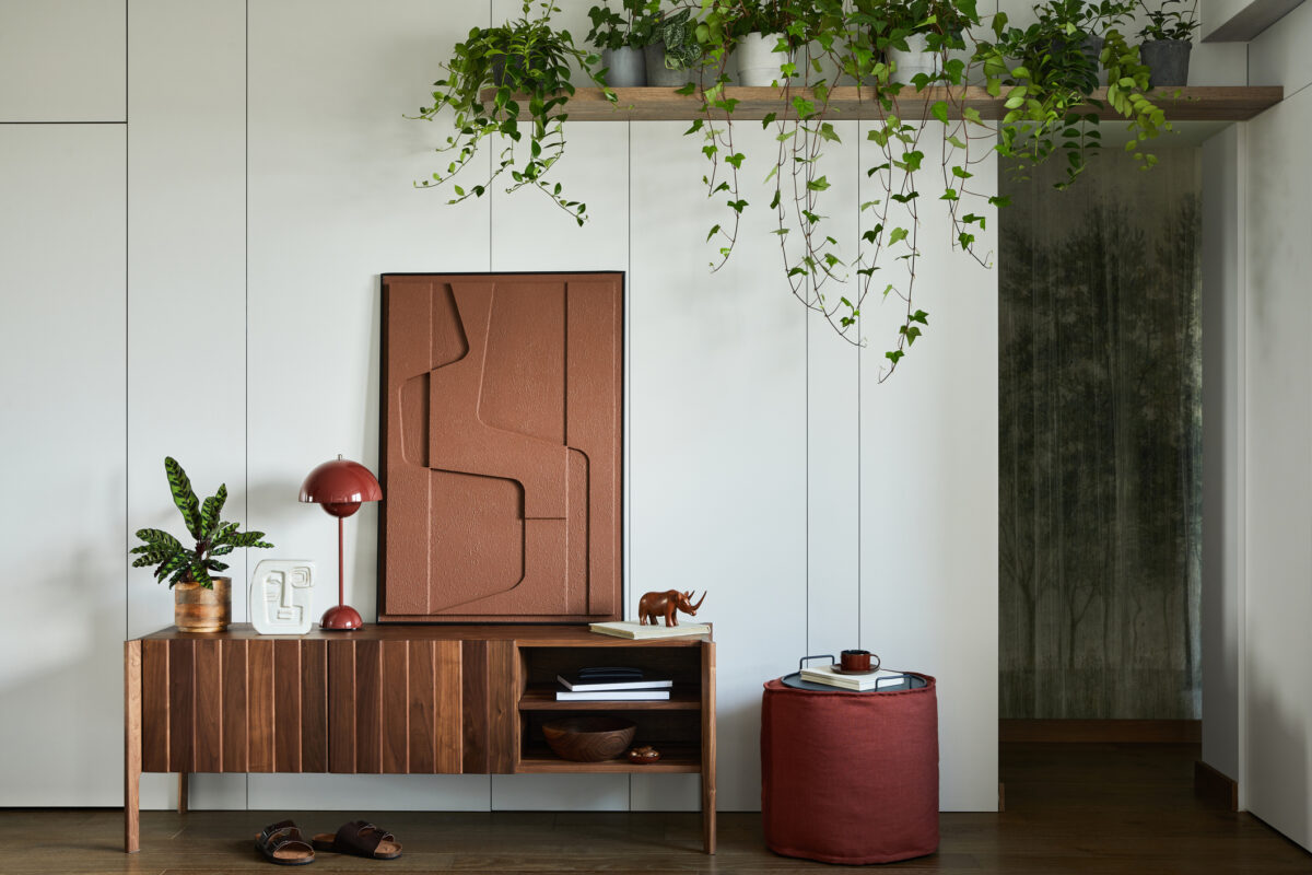 Stylish living room interior design with mock up structure painting. Wooden commode, a lot of plants. Creative walls with panels. Minimalistic style and plant love concept.