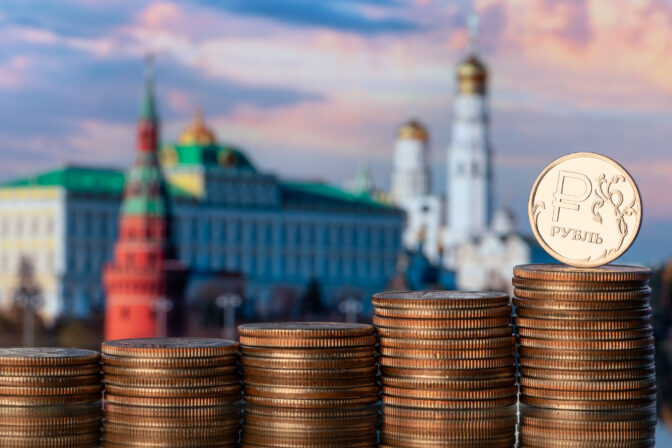 Coin with the symbol of the Russian ruble against the backdrop of the Moscow Kremlin