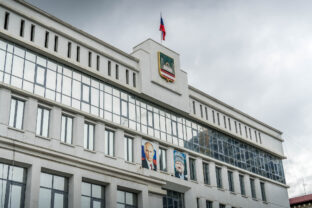 The city administration in Grozny, Republic of Chechnya, with the flag and coat of arms, and portraits of Vladimir Putin and Akhmad Khadzhi Kadyrov.