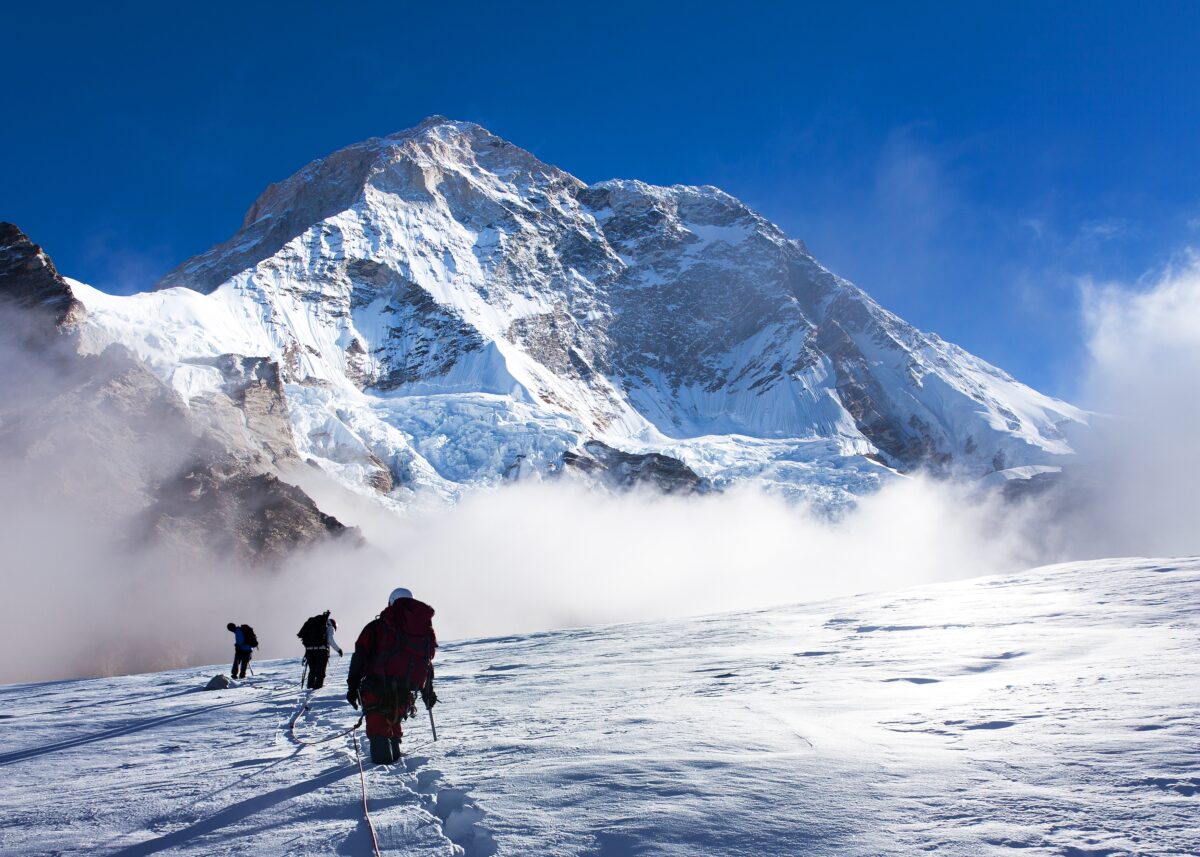 Group of climbers on rope on glacier and Mount Makalu