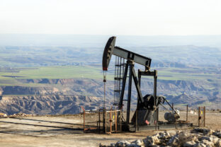 View of the pumpjack in the oil well of the oil field. The arrangement is commonly used for onshore wells producing little oil. Pumpjacks are common in oil rich areas.