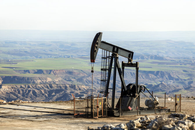 View of the pumpjack in the oil well of the oil field. The arrangement is commonly used for onshore wells producing little oil. Pumpjacks are common in oil rich areas.