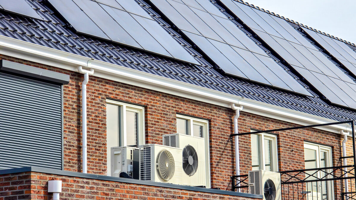 Air source heat pump unit installed outdoors at a modern home with solar panels in the Netherlands