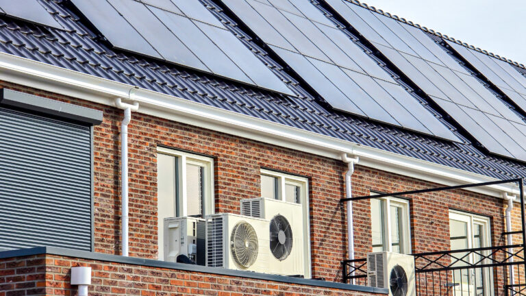 Air source heat pump unit installed outdoors at a modern home with solar panels in the Netherlands