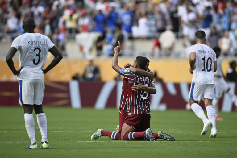 Radosť a smútok na jednej fotografie. V strede futbalisti Fluminense po postupe do semifinále MS klubov a po bokoch smutní hráči Al-Hilalu.