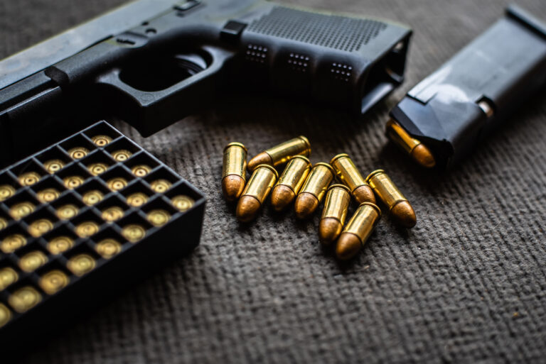 Bullets and gun on black velvet desk