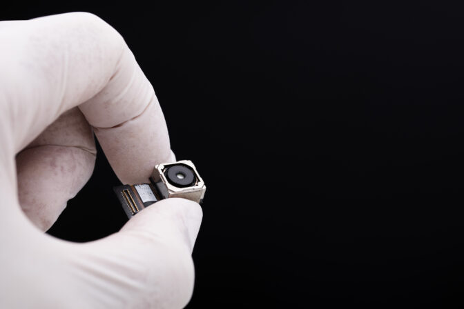Small spy camera in hand concept on black background