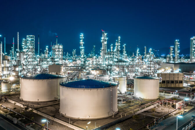 Oil refinery plant from industry zone, Aerial view oil and gas industrial, Refinery factory oil storage tank and pipeline steel at night.