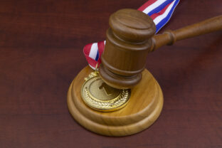 Medal and wooden judge's gavel, sport arbitration court concept.
