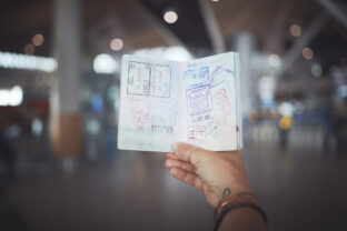 Cropped shot of a woman showing her passport stamps at the airport