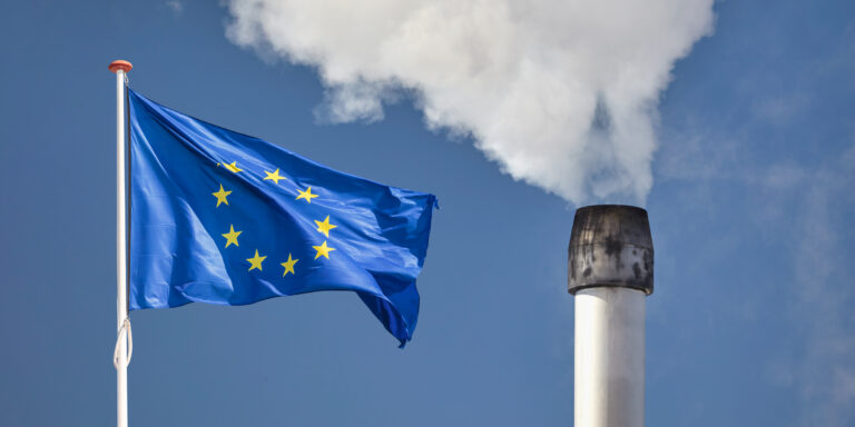 European flag in front of a factory chimney