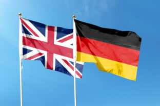 Union Jack and German flag on cloudy sky. waving in the sky