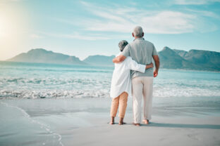 Back, hug or old couple on beach to relax with love, care or support on summer vacation in nature. Retirement, mature man or senior woman at sea or ocean to travel on holiday together looking at view