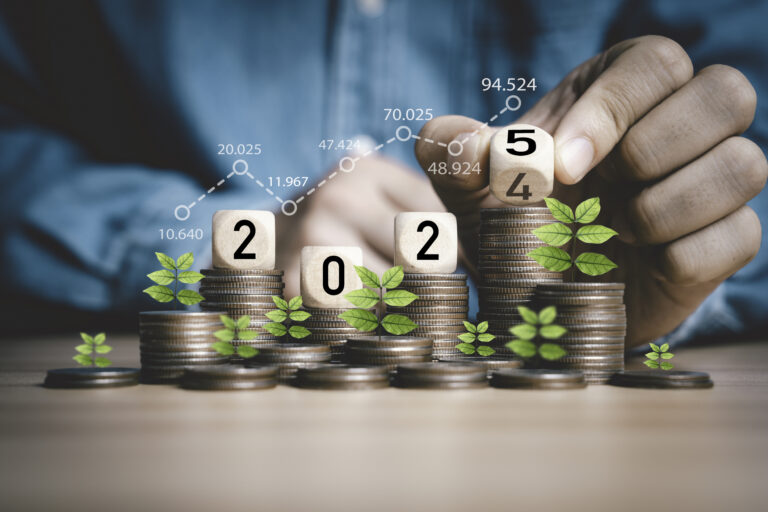 Businessman hand flipping wooden block cube from 2024 to 2025 on coins stacking for business budget planing and investment growth of new year con