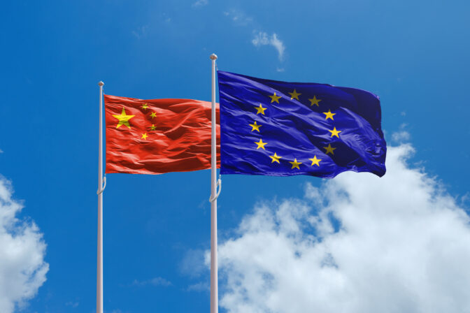 EU and China flags above blue sky. China and Europe Union trade war.