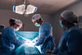 Doctors performing surgery under well lit operating room conditions
