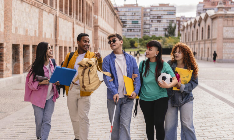 Blind university student walking with friends on campus