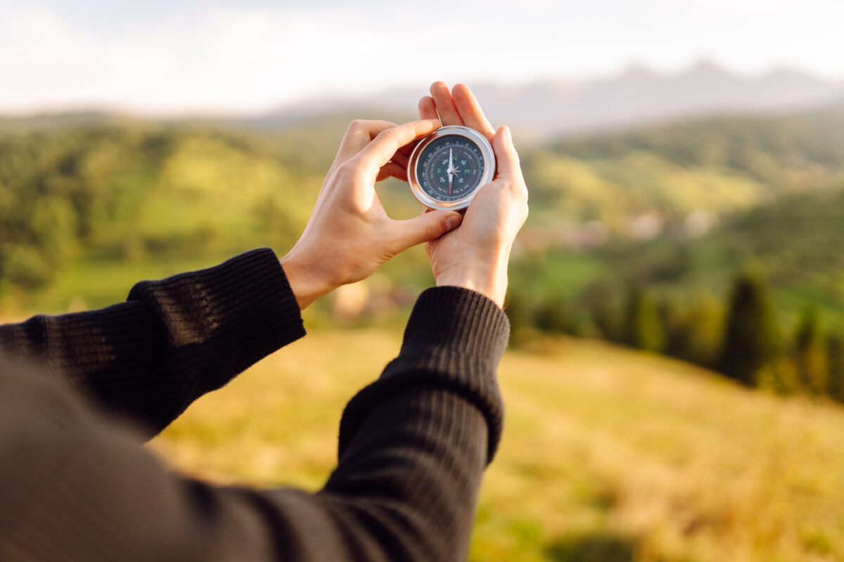 Close up of tourist's hand with compass.