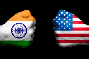 Flags of India and United States painted on two clenched fists facing each other on black background/India - USA tariff conflict concept