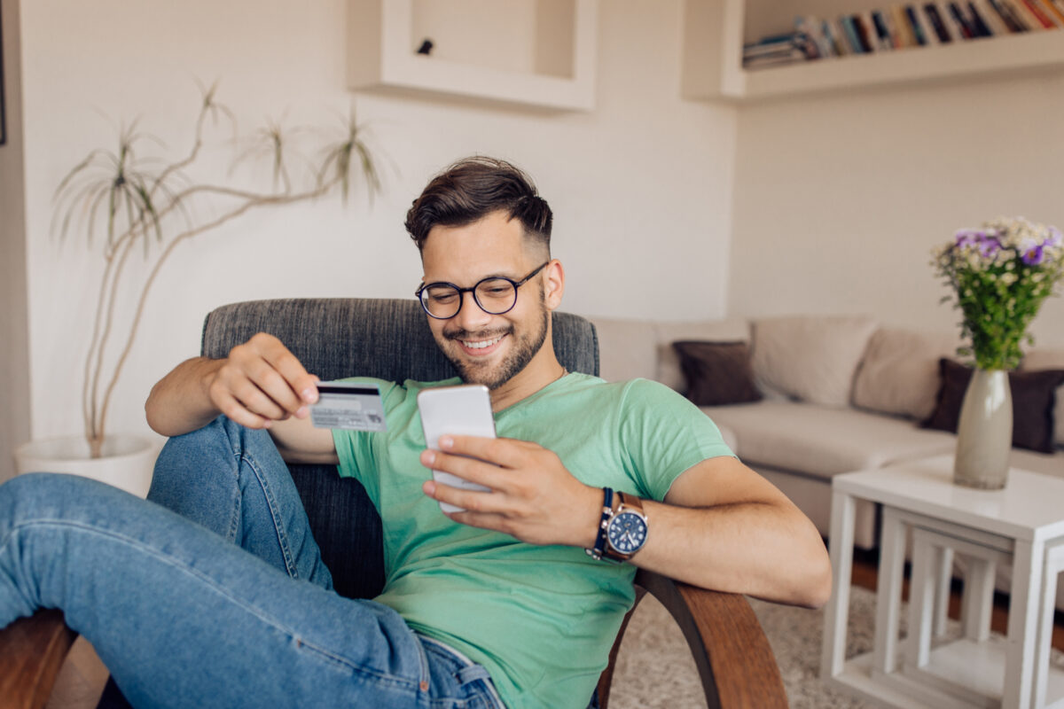 Happy young man shopping online at home