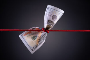 American dollar tied up in red rope knot on dark background with copy space. business finances, savings and bankruptcy concept.