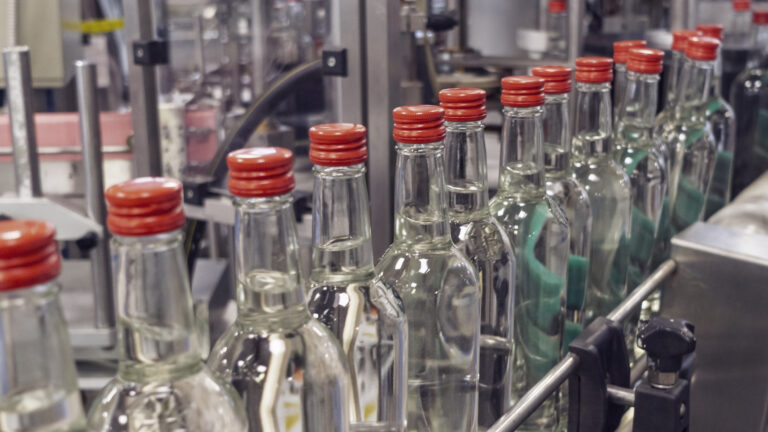 The bottles on the conveyor belt at the plant for bottling of alcoholic beverages, Russian vodka