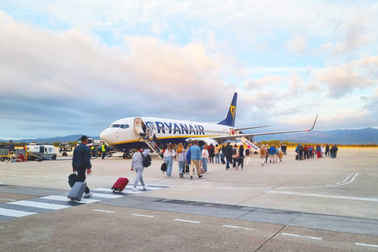Travelers Boarding Ryanair Plane at Airport Runway during Sunset