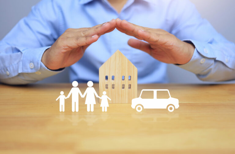 Life insurance concept with businessman using his hands to protect his family home and car, meaning to protect the health and property of the people in the home and to plan for the future.