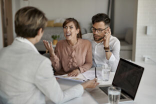Displeased couple arguing with their real estate agent during a meeting.