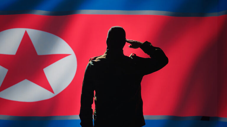 Secret intelligence agent doing saluting hand gesture towards North Korea flag