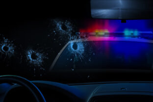 Police car and bullet holes in glass