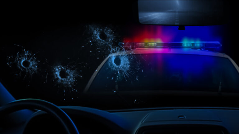 Police car and bullet holes in glass