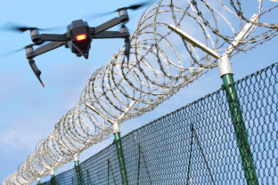 Drone monitoring barbed wire fence on state border or restricted area.